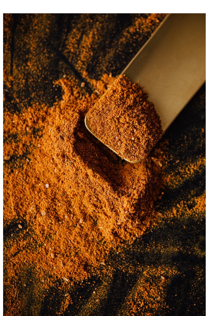 A spoon is in some ground curry powder